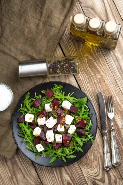 Pancar salatası, peynir, roka ve kırsal bir arka planda baharatlı sos. Sağlıklı yiyecekler. Üst Manzara. Boşluğu kopyala.