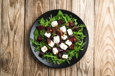 Pancar salatası, peynir, roka ve kırsal bir arka planda baharatlı sos. Sağlıklı yiyecekler. Üst Manzara. Boşluğu kopyala.