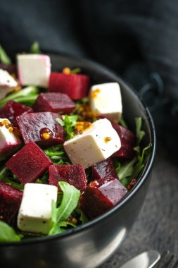 Pancar salatası, beyaz peynir, roka ve koyu arkaplanda baharatlı sos. Sağlıklı yemek.. 