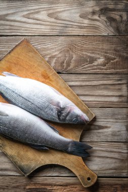 Taze deniz kabuğu. Tahta kırsal masada çiğ balık deniz kabuğu. Kopyalama alanı olan üst görünüm