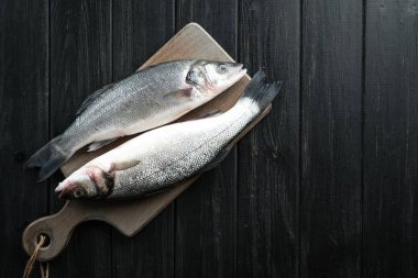 Taze deniz kabuğu. Siyah kırsal masada çiğ balık deniz kabuğu. Kopyalama alanı olan üst görünüm