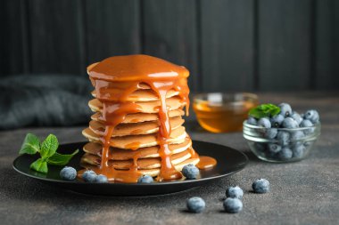Taze yaban mersinli, çilekli ve karamel arkaplanlı lezzetli gözlemeler..