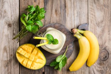 Kırsal bir zeminde Mason kavanozunda nefis bir mango püresi. Sağlıklı yemek, detoks diyeti. Boşluğu kopyala