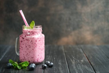 Mason kavanozunda koyu kırsal bir arka planda lezzetli yaban mersini püresi. Sağlıklı yemek, detoks diyeti. Boşluğu kopyala.