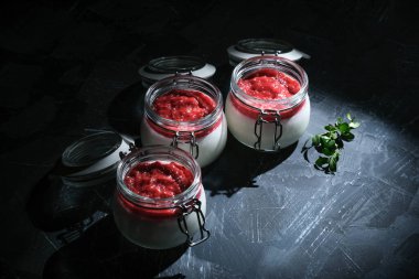 Klasik İtalyan tatlısı kremalı panna cotta. Üzerinde kiraz sosu ve koyu kırsal arka plan fotokopi alanı var..