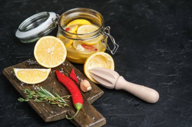 Koyu arkaplanda cam kavanozda tuzlanmış limon. Fas mutfağı.