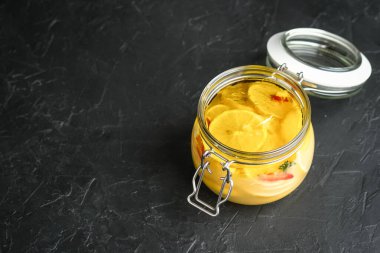 Koyu arkaplanda cam kavanozda tuzlanmış limon. Fas mutfağı.