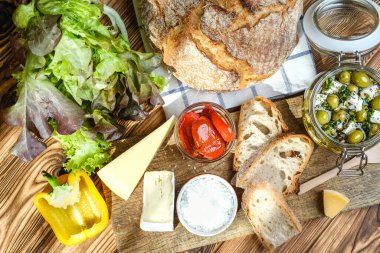 Akdeniz kahvaltısı için çeşitli ürünler: zeytin, ekmek, peynir, otlar ve sebzeler. Sağlıklı yiyecekler.
