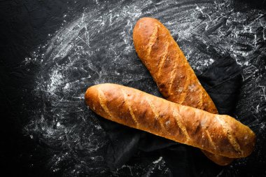 Koyu arkaplan arkaplanındaki geleneksel Fransız ekmeği kopyalama alanı.