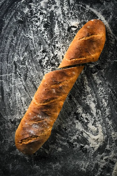 Traditional french baguettes on a dark background top view copy space.