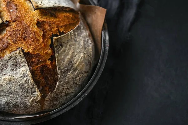 Ekmek. Koyu bir arka plan fotokopi alanında ev yapımı tahıl ekmeği ve fırın kabı..