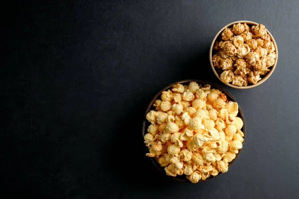 Popcorn. Cheese and caramel popcorn on a dark background. Top view copy space.