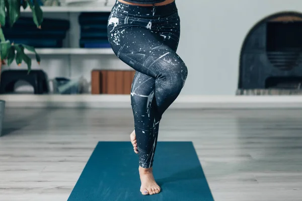 Yoga kartalı pozunda bacak bacak bacak üstüne atmış bir kadın. Meditasyon, konsantrasyon ve farkındalık egzersizi.