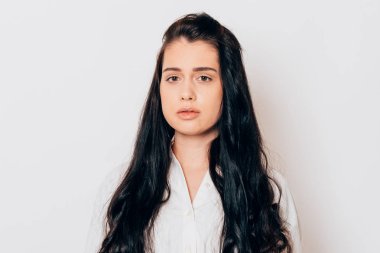 Beyaz arka planda uzun siyah saçlı, şehvetli bir genç kadının portresi. 