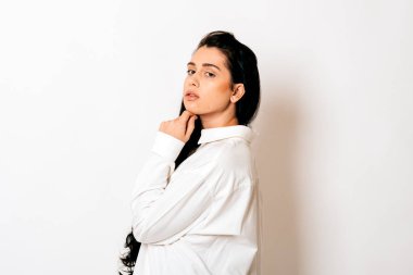 Beyaz arka planda uzun siyah saçlı, şehvetli bir genç kadının portresi. 