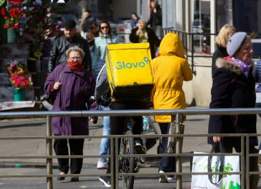 Bükreş, Romanya - 11 Mart 2020: Bir Glovo gıda dağıtım kuryesi Romanya 'nın Bükreş kentinde gıda dağıtıyor.