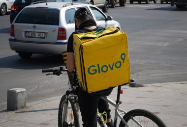 Bükreş, Romanya - 30 Mart 2020: Bir Glovo gıda dağıtım kuryesi Romanya 'nın Bükreş kentinde gıda dağıtıyor.