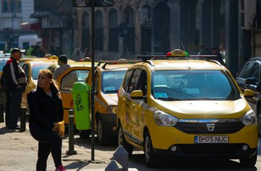 Bükreş, Romanya - 20 Şubat 2019: Bükreş şehir merkezindeki bir taksi durağında sarı taksiler park halinde..