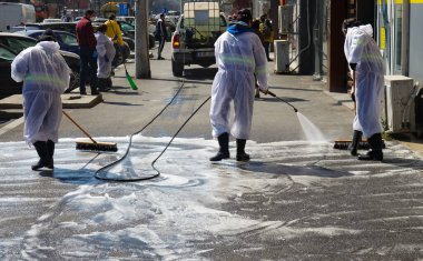 Bükreş, Romanya - 03 Nisan 2020: Temizlik çalışanları Coronavirus 'un yayılmasını önlemek amacıyla çevreye duyarlı köpüklerle sokakları temizliyorlar.