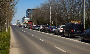 Bükreş, Romanya - 08 Nisan 2020: Romanya 'nın başkenti Bükreş ile Voluntari arasındaki demiryolu bariyerinde uzun bir otomobil kuyruğu.