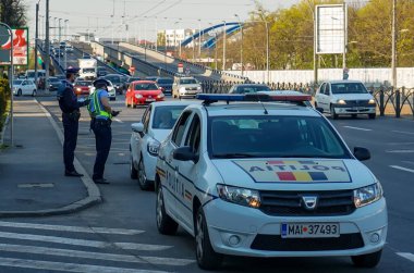 Bükreş, Romanya - 09 Nisan 2020: Polis memurları, gerekli Home Exit sertifikalarına sahip olup olmadıklarını kontrol ederek trafikte sürücüleri kontrol ediyorlar. Romanya koronavirüs yüzünden tecrit altında.
