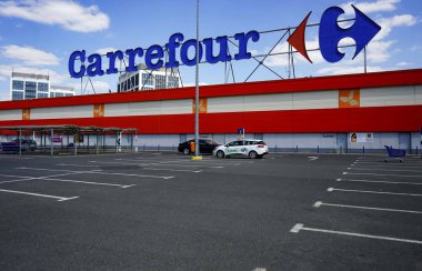 Bükreş, Romanya - 23 Nisan 2020: Bükreş 'teki Orhideea Alışveriş Merkezi' nde çok uluslu Fransız perakendecisi Carrefour 'un boş otoparkı görülüyor. Romanya koronavirüs yüzünden tecrit altında.