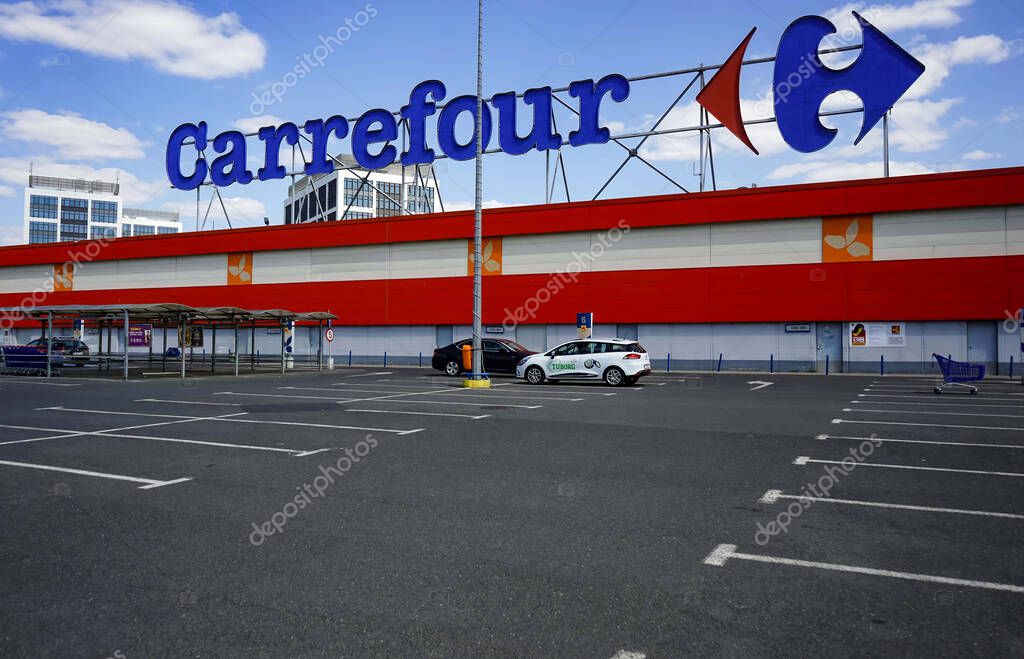 Bucharest, Romania - April 23, 2020: Empty parking lot of French multinational retailer Carrefour is seen at the Orhideea Shopping Center in Bucharest. Romania is in lockdown due to coronavirus.