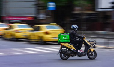 Bükreş, Romanya - 07 Mayıs 2020: Bir Uber yüksek hızda scooterla gıda dağıtım kuryesi yiyor. Restoranlar kapalıdır ve sadece acil durumlarda Coronavirus nedeniyle teslimatlara izin verilir.