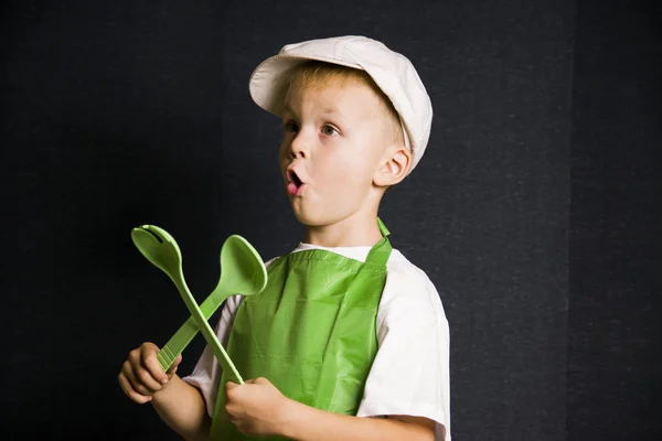 Divertente ragazzo con un cucchiaio e forchetta — Foto Stock