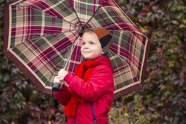 Divertente ragazzo stand sotto un ombrello — Foto Stock