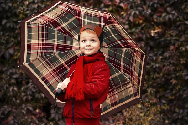 Divertente ragazzo stand sotto un ombrello — Foto Stock