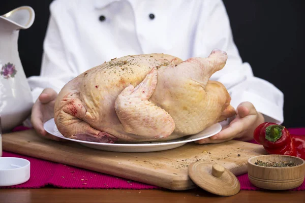 Jongen chef-kok bereidt een kip — Stockfoto