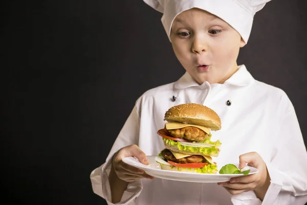 Jungenkoch bereitete einen großen Hamburger zu — Stockfoto