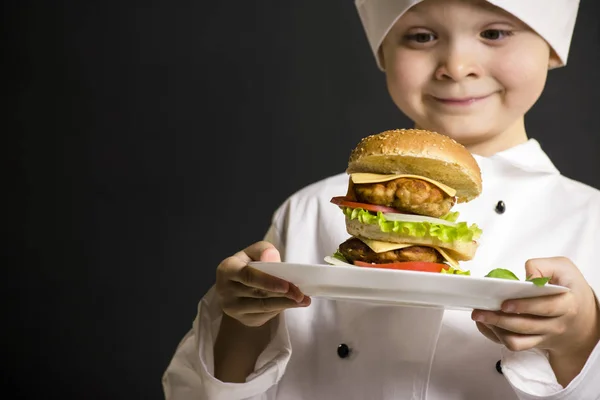 Jungenkoch bereitete einen großen Hamburger zu — Stockfoto