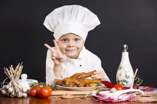 Szef kuchni chłopiec nogi kurczaka gotowane — Zdjęcie stockowe