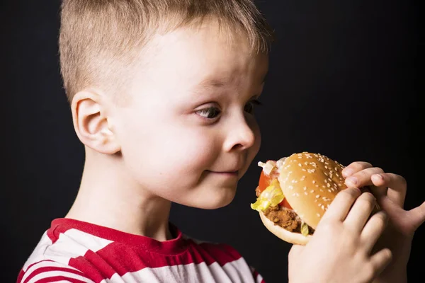 Junge isst einen Hamburger — Stockfoto