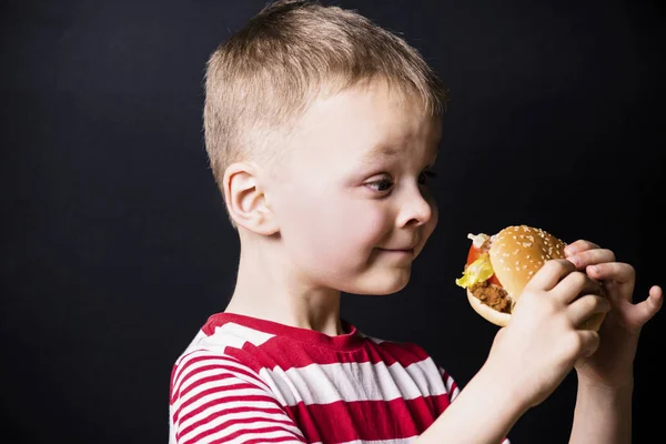 Junge isst einen Hamburger — Stockfoto
