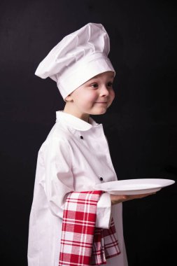 Çocuk aşçı temiz bir tabak tutar