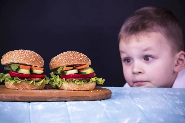 Chico mirando una hamburguesa — Foto de Stock