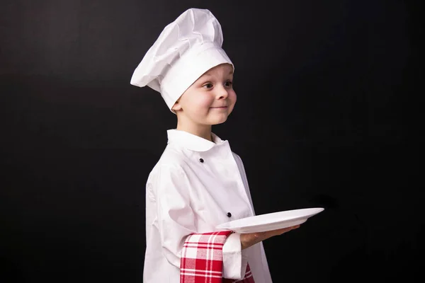 Chłopiec kucharz trzyma czystym talerzu — Zdjęcie stockowe
