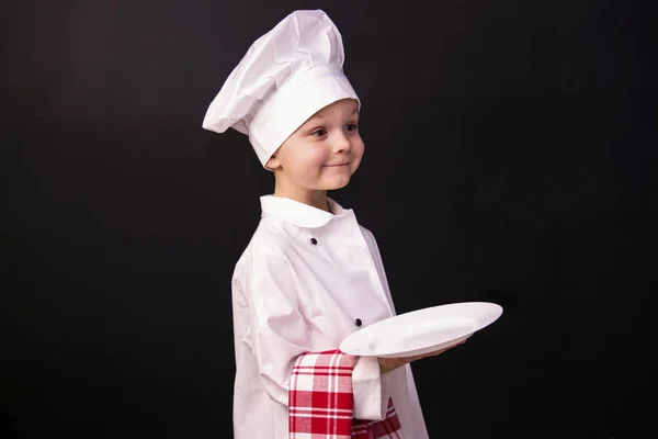 Chłopiec kucharz trzyma czystym talerzu — Zdjęcie stockowe