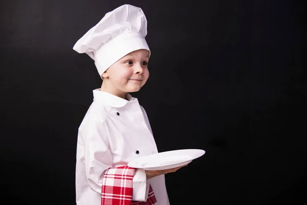 男孩的厨师保持一个干净的盘子 — 图库照片