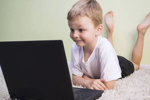 Engraçado menino jogando no laptop — Fotografia de Stock