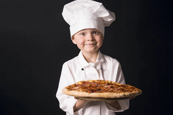 Kucharz chłopca gospodarstwa pizza salami — Zdjęcie stockowe