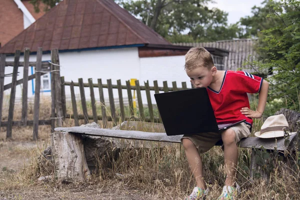 The boy is looking at laptop — Stock Photo, Image