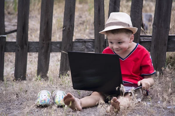 Мальчик смотрит на ноутбук — стоковое фото