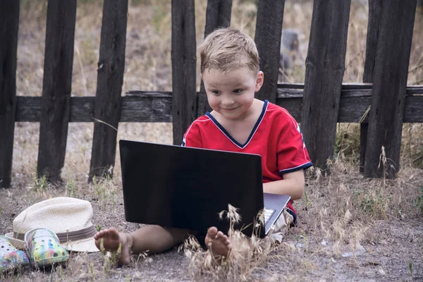 De jongen kijkt laptop — Stockfoto