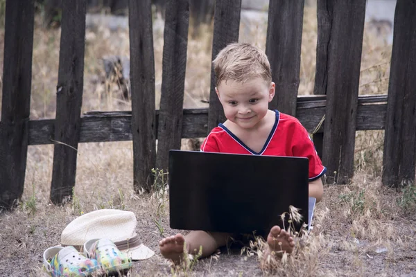 El chico está mirando el portátil — Foto de Stock