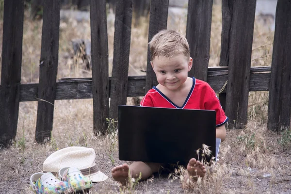 The boy is looking at laptop — Stock Photo, Image