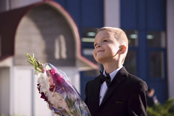 Boy in a suit with a bouquet — Stock Photo, Image